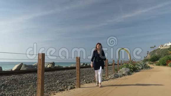 女人快乐美丽阳光夏日漫步海洋海岸旅行假期退休生活方式加州概念视频的预览图