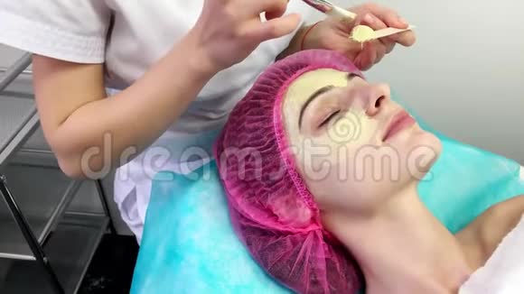美丽的年轻女子在美容院接受面部护理视频的预览图