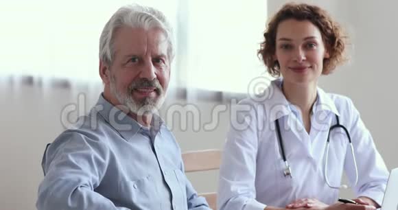 微笑老年男性病人看女医生看镜头视频的预览图