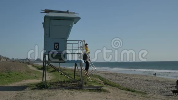 女人站在救生塔在夏日挥手旅行假期退休生活方式加州概念视频的预览图