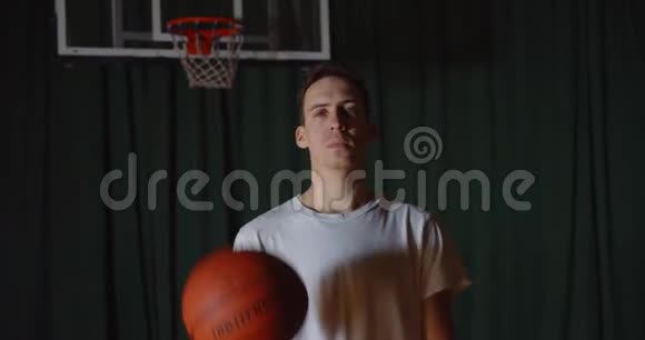 一幅广受欢迎的白种人篮球运动员肖像画在严肃自信的外表背景下玩篮球视频的预览图