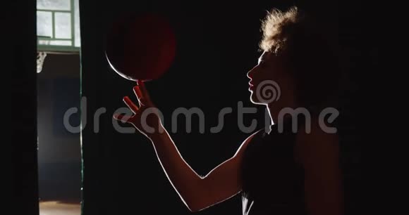 年轻的白种人卷发篮球运动员准备好剪影时手指上的把球扭曲了视频的预览图