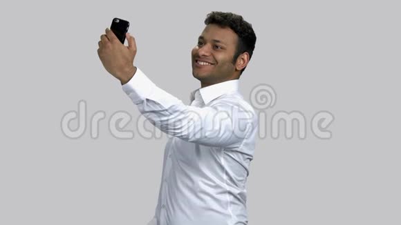 年轻的印度教男人在他的正面相机上摆姿势和自拍视频的预览图