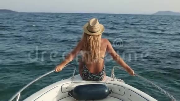 坐在船甲板上欣赏海景的年轻女子视频的预览图