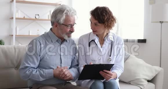 女医生在解释处方的时候和老男病人交谈视频的预览图