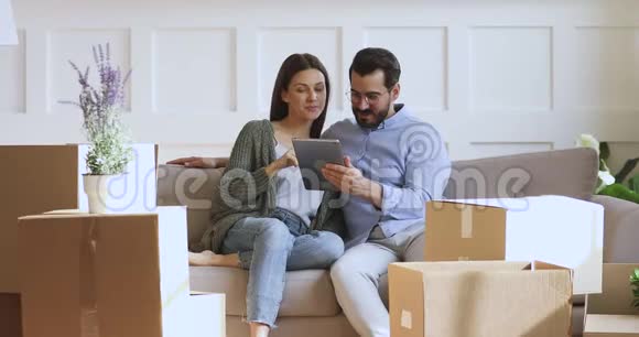 幸福的家庭夫妇在新公寓网上订购家庭装饰品视频的预览图