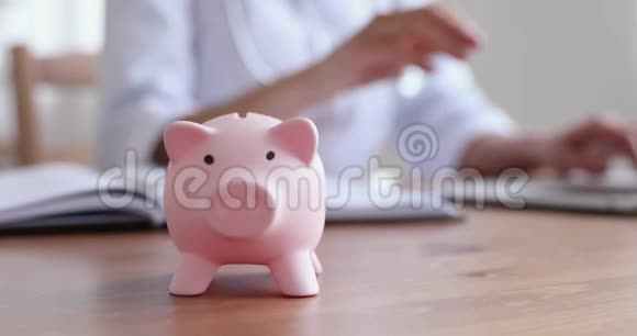 小猪银行在桌上女医生在后台工作视频的预览图