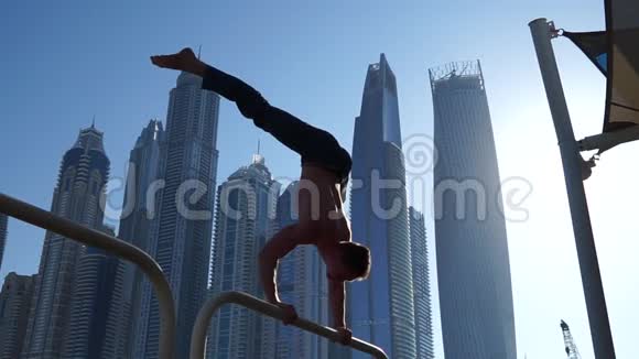 肌肉男在街上锻炼背景是迪拜的摩天大楼健康观念视频的预览图