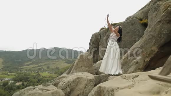 美丽可爱的新娘站在山上恋爱中的女人视频的预览图
