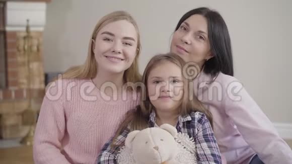 成年白种人妇女十几岁的女孩和小可爱的孩子看着相机和微笑的肖像友好快乐视频的预览图