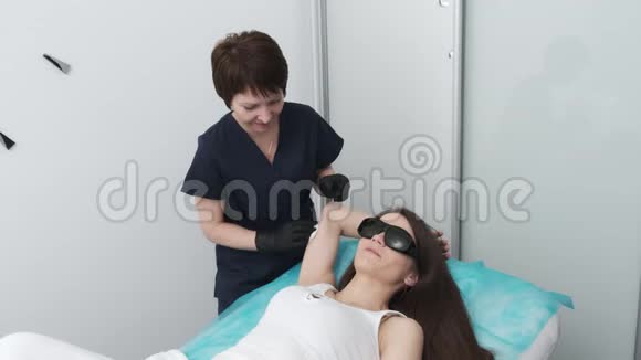 在激光脱毛后美容师在病人身上擦拭残留的凝胶视频的预览图