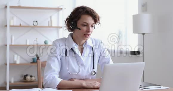 医疗助理戴耳机视频电话远程病人笔记本电脑视频的预览图