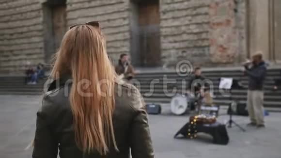 年轻女子随着乐队在街上演奏的音乐跳舞视频的预览图