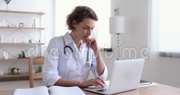 女医生穿着白大褂手提笔记视频的预览图