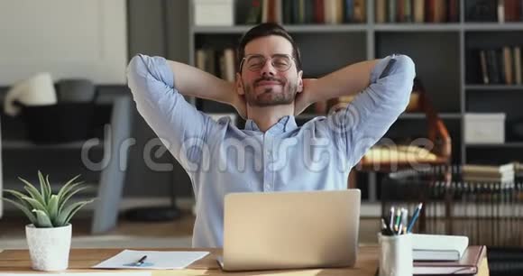 满意的员工在办公桌前放松双手握在头后视频的预览图