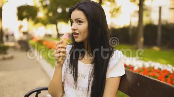 年轻美女微笑着吃冰淇淋慢动作高清视频视频的预览图