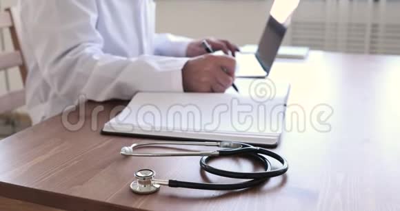 餐桌上使用听诊器的高级医生的特写镜头视频的预览图