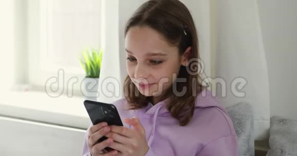 微笑少女使用智能手机与朋友在家聊天视频的预览图