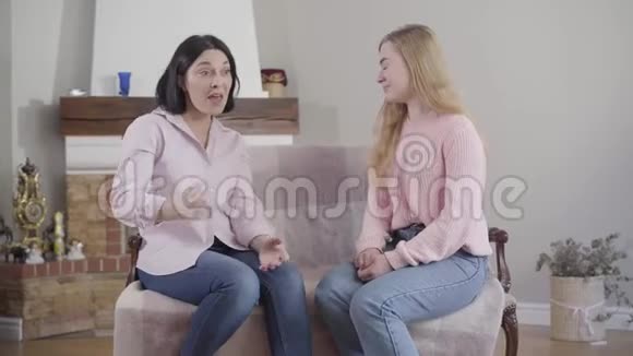 白种人成年女性与十几岁的金发女儿在感情上交谈的肖像妈妈和小女孩分享想法视频的预览图