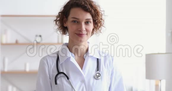 微笑的女性心脏病专家看着摄像机视频的预览图