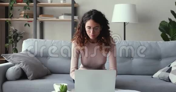 兴奋的女赢家看着笔记本电脑在家庆祝成功视频的预览图