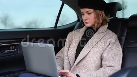 商务女性使用笔记本电脑坐在汽车后座视频的预览图