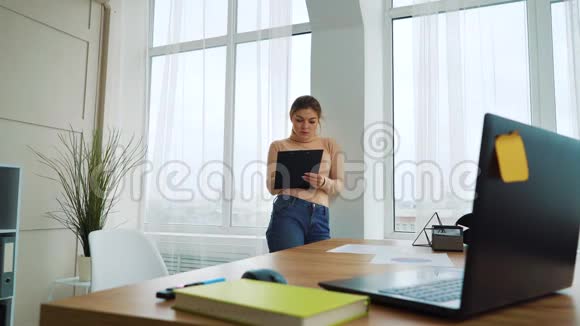 穿着剪贴板的性感女孩在现代办公室工作视频的预览图