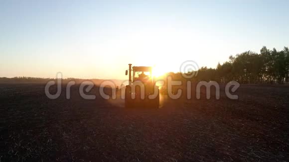 农民在自然农场耕作田用拖拉机进行的农村农业劳动视频的预览图