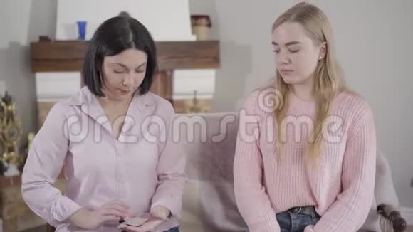 年轻的黑发白种人母亲给她十几岁的女儿避孕套聪明的女人照顾她成年的孩子信托基金视频的预览图