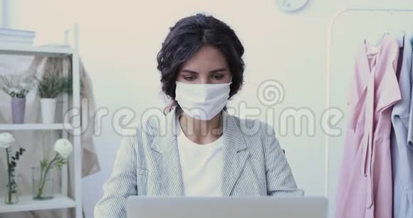 生病的年轻女商人用电脑咳嗽戴着口罩视频的预览图