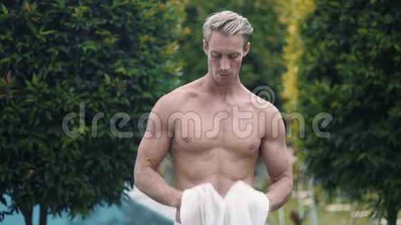 游泳后性感男士用毛巾擦拭脸部和身体视频的预览图