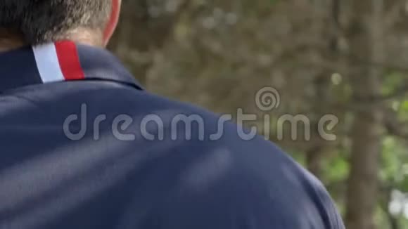一个英俊的年轻人一个穿着海军蓝衬衫短裤和眼镜的男人正沿着加利福尼亚海岸圣克莱门特走着视频的预览图