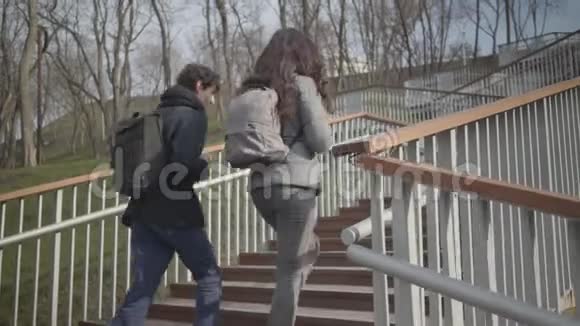 十几岁的白人夫妇在城市公园上楼梯男孩和女孩在户外散步时聊天男性和女性视频的预览图