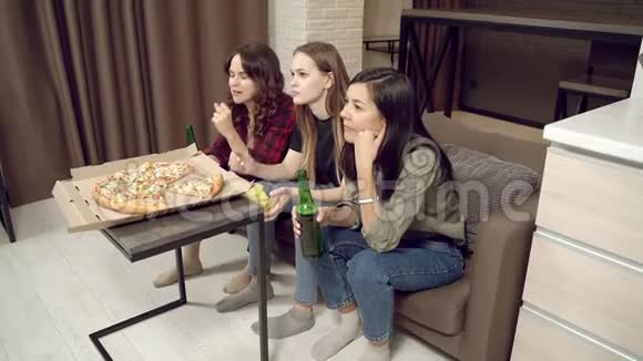 一群年轻女性喝着啤酒情绪激动地支持她们最喜欢的团队在家看电视视频的预览图