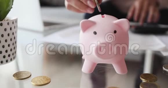 计算财务的女人把钱放进储蓄罐特写视频的预览图