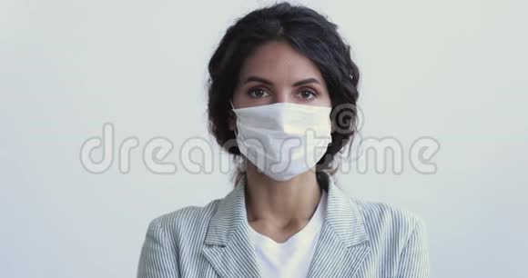 年轻女子戴着医用面罩呼吸着镜头视频的预览图