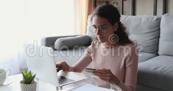 年轻女子持信用卡在网上支付笔记本电脑视频的预览图