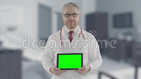 一位自信的医生拿着绿色屏幕的现代平板电脑肖像拍摄于红色相机阿尔法哑光图片视频的预览图