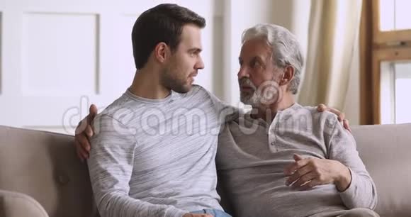 微笑的年轻人在家里和年迈的父亲交流视频的预览图
