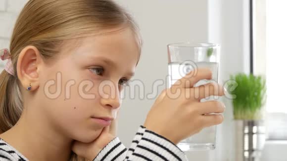 孩子在厨房里喝水口渴的十几岁女孩在学习一杯淡水孩子的医疗保健视频的预览图