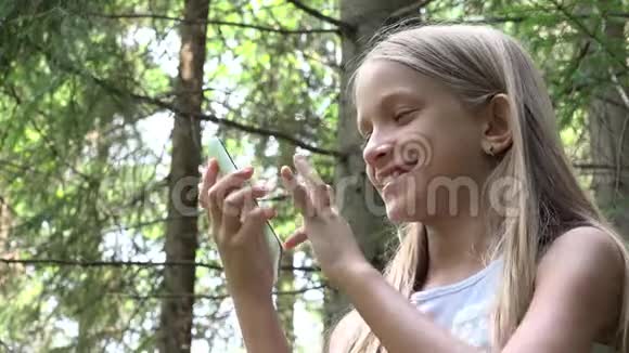孩子们在户外露营玩平板电脑孩子们用智能手机浏览互联网十几岁的女孩在森林里视频的预览图