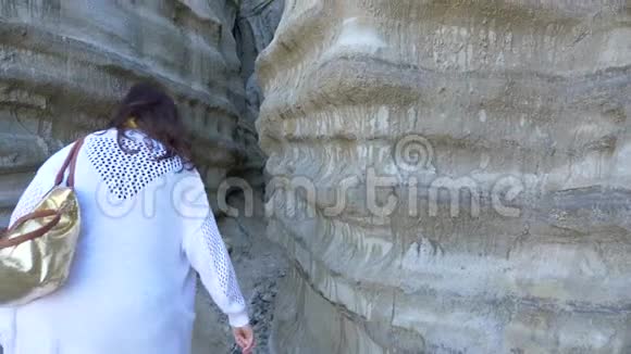 在加州圣克莱门特卡拉菲亚海滩上一位活跃的资深女性穿过沙峡谷悬崖橙色县生活方式视频的预览图