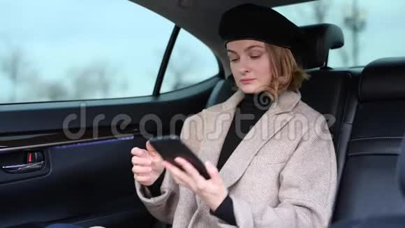 使用智能手机进行视频聊天的女人坐在汽车后座视频的预览图