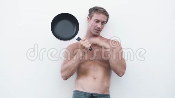 性感男人带着煎锅微笑显示OK标志在相机上调情视频的预览图
