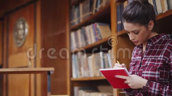 在图书馆学习的年轻学生女孩视频的预览图
