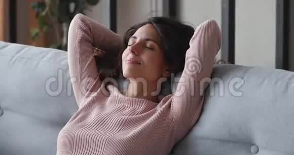 舒适的沙发上休息的快乐轻松的单身女士视频的预览图