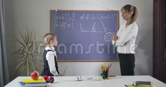 可爱的白种人女孩仔细听成人导师解释她的数学公式很漂亮的女生学习视频的预览图