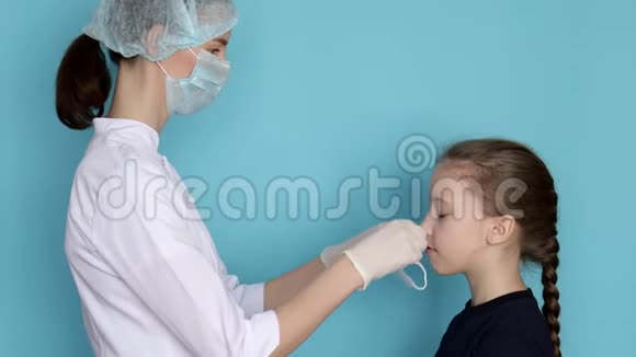 女医生给女孩子戴上口罩预防冠状病毒视频的预览图
