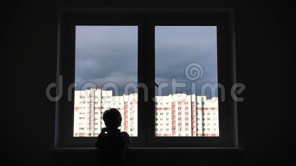 一个孤独的孩子望着公寓里他房子的窗户视频的预览图