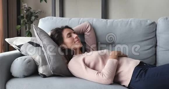 躺在舒适的沙发上睡觉的年轻女子放松了视频的预览图